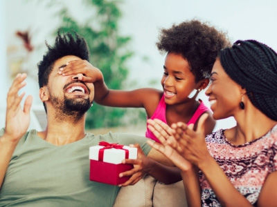 A child and mom giving a gift to dad on Father's Day