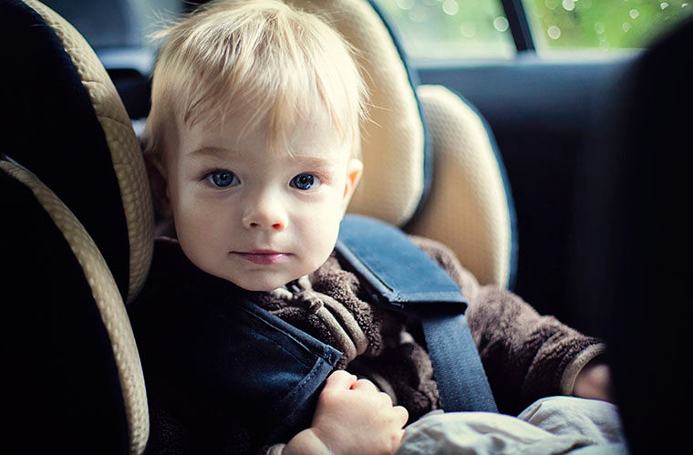 Toddler riding in his car seat during a road trip.