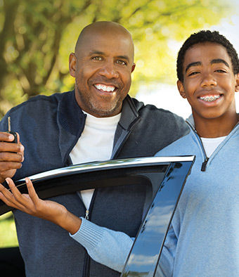 Teen driver with his father getting keys.