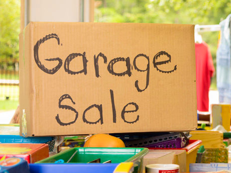 Consumerism:  Adult women buying at a yard sale in suburbs