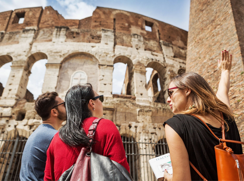 A tour guide with a couple in front of the Colosseum. 