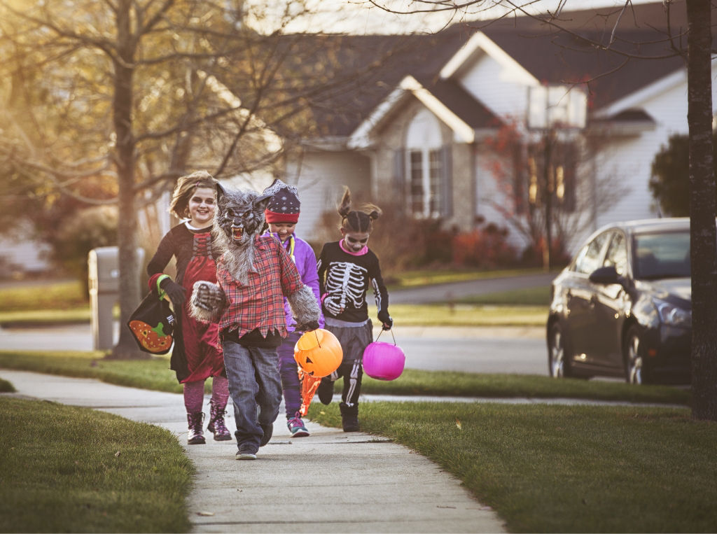 children out trick or treating in neighborhood.