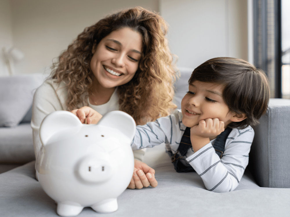 Portrait of a happy Latin American single-parent-family saving money in a piggybank