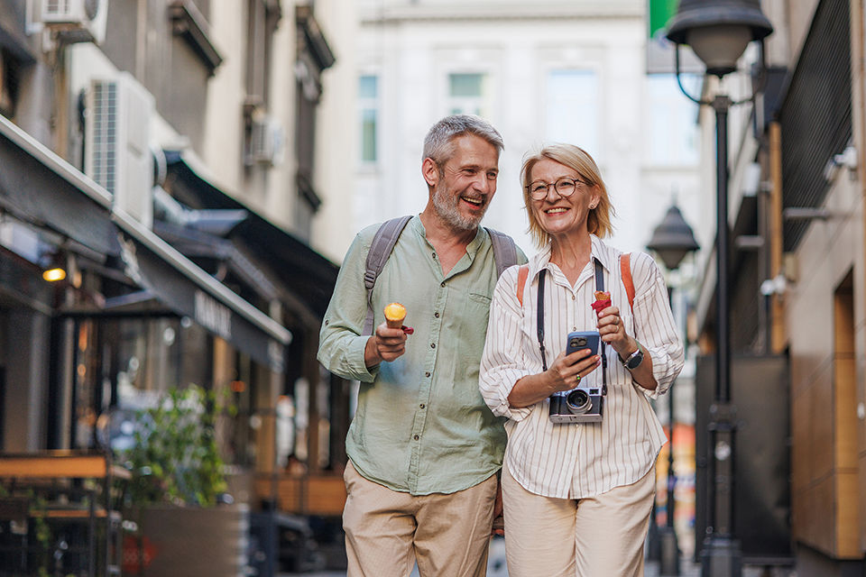 A couple enjoys a city walk, sharing joyful moments while traveling.