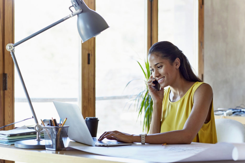 Woman on her phone sitting at a desk