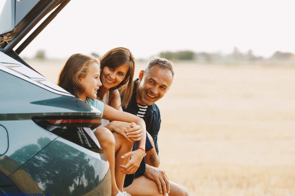 Family sitting in the back of their car.
