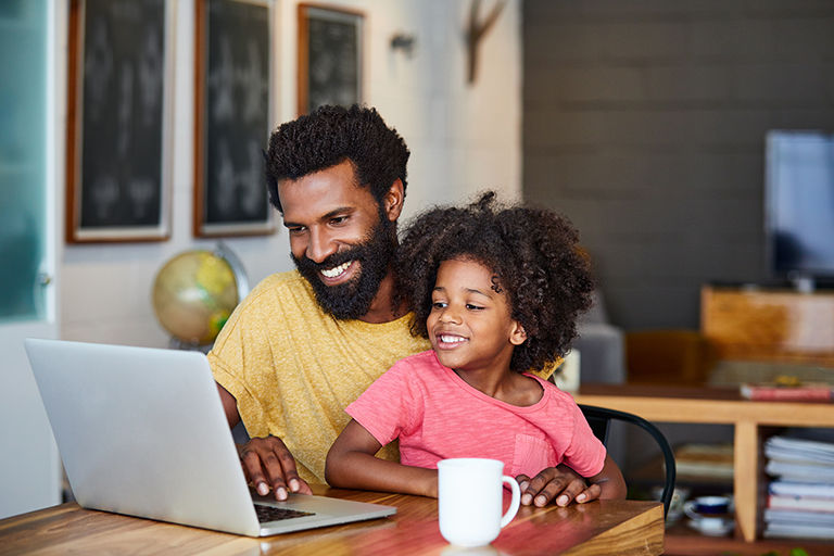 Father and daughter looking at the computer. 