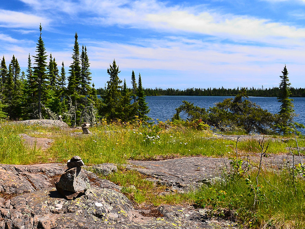 Isle Royale National Park hiking trail over rocky terrain with cairns to mark the route.