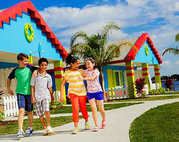 Group of kids walk through legolands stay and play smiling and laughing together.