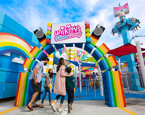 A family is walking into one of Legolands top attractions. 