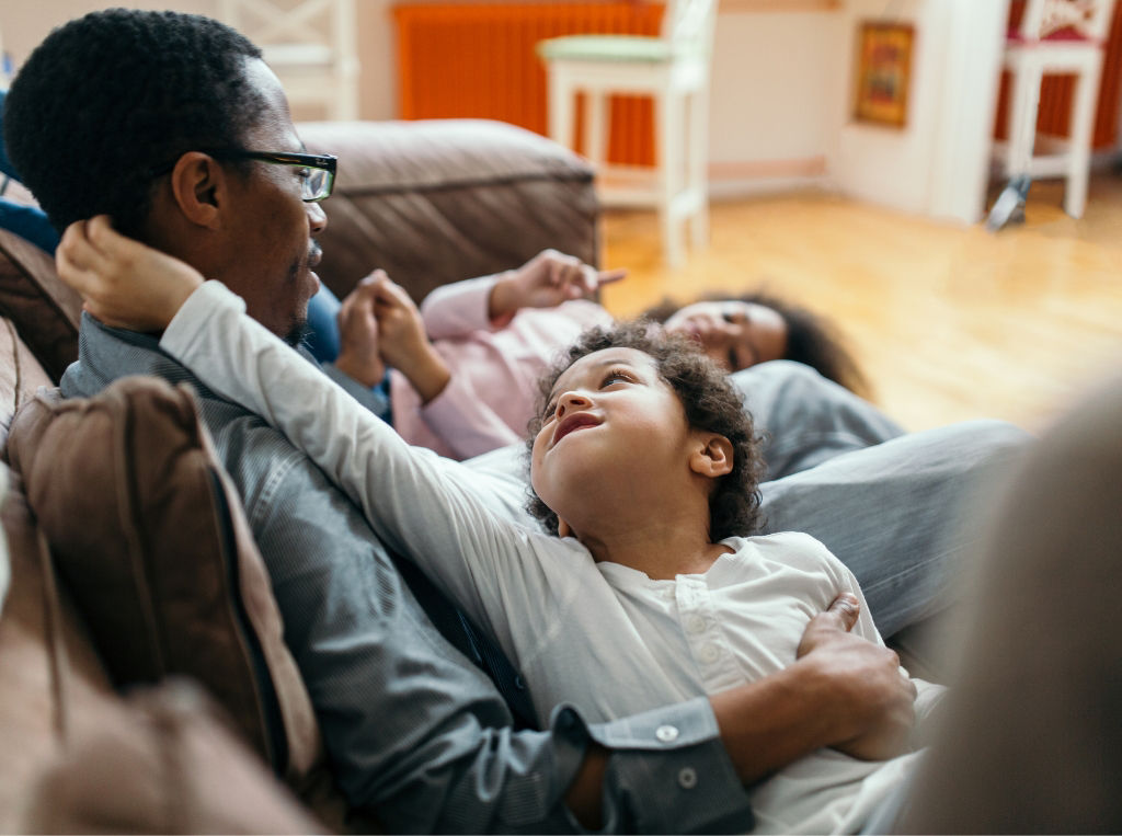 Father and children sitting on a sofa. 
