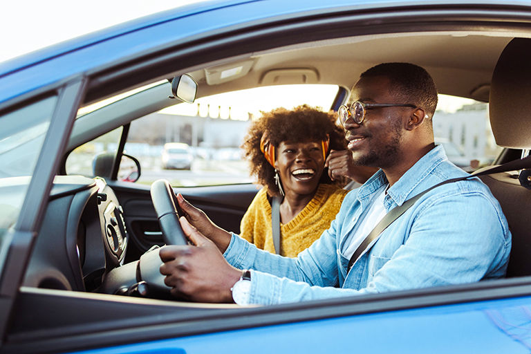 Couple driving away in their new bought car.