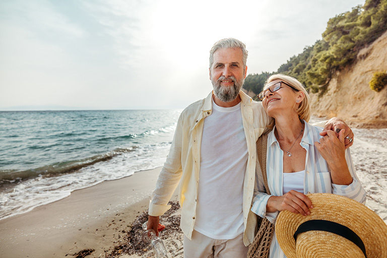 Couple on a luxury vacation walking on the beach.