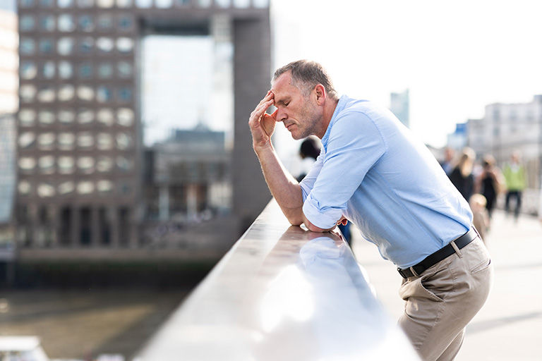 Man not feeling good, leaning on bridge at London, UK