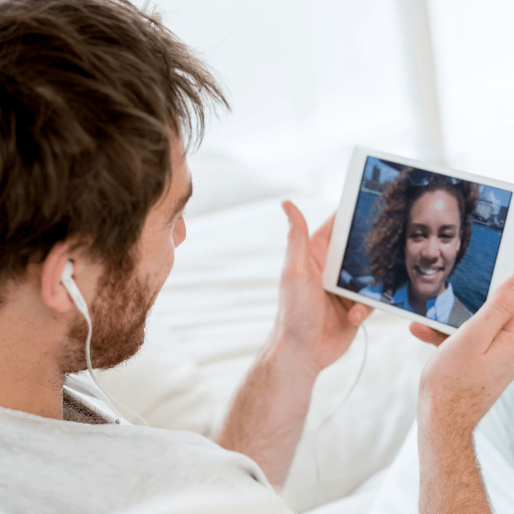 Man web chatting on a tablet with a friend traveling