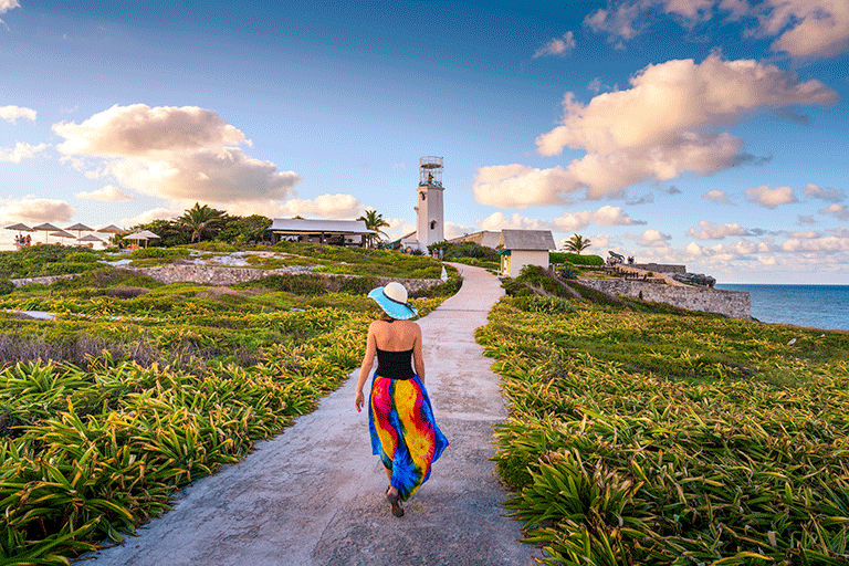 A woman walking toward the lighthouse in Mexico.