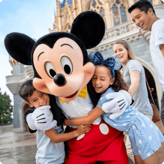 Young family hugging Mickey Mouse at Walt Disney World Resort