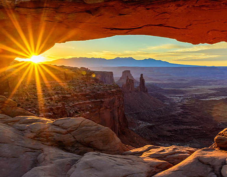 Sunset seen through a stone arch in Moab, Utah.