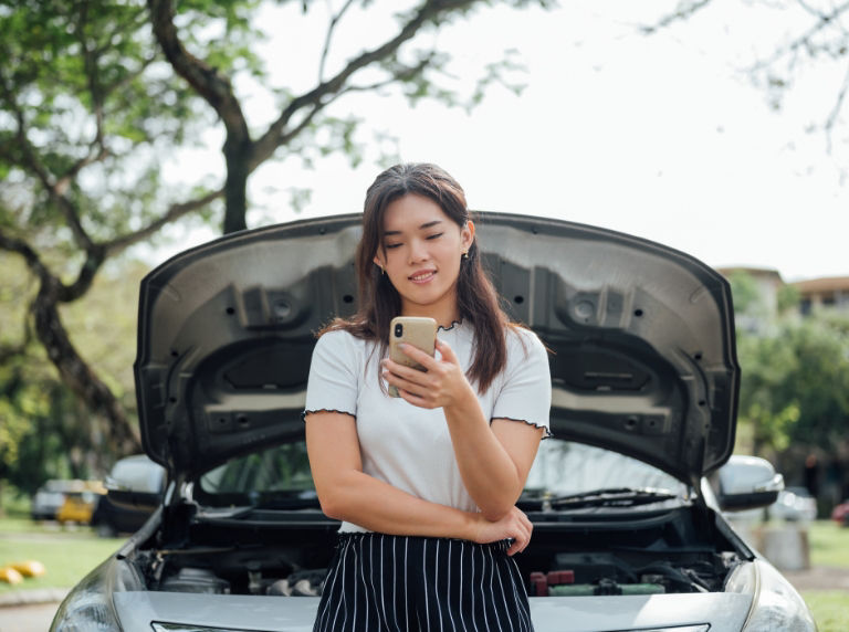 woman on phone by car