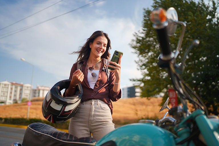 Motorcyclist checking her phone