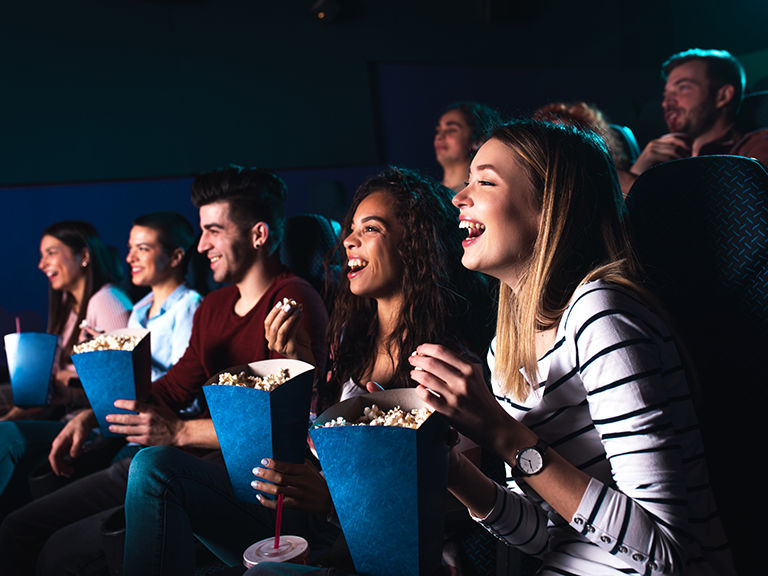 AAA members enjoy a memorable movie theater experience with friends, sharing laughter, popcorn, and refreshments while watching the latest movies.