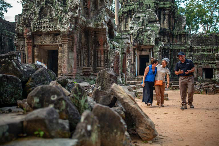 Guide leading tourists through ancient temple complex in Cambodia