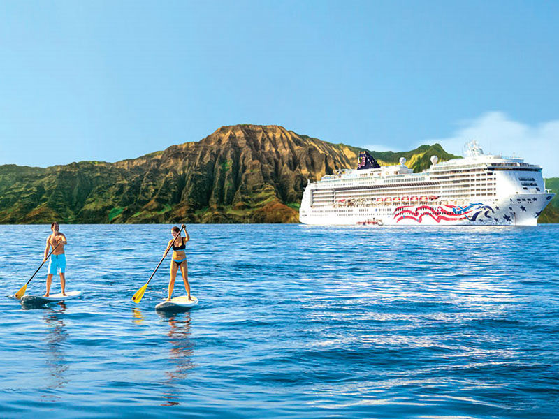 Picture of a NCL ship off of Hawaii with two paddle boarders in the foreground