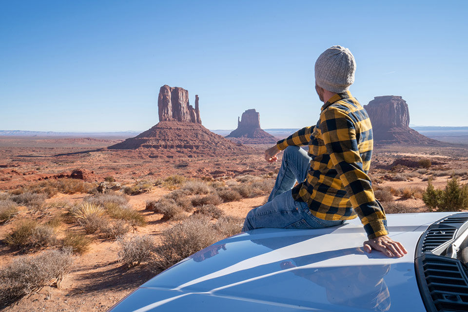 Young man, parked on the road enjoying the view.