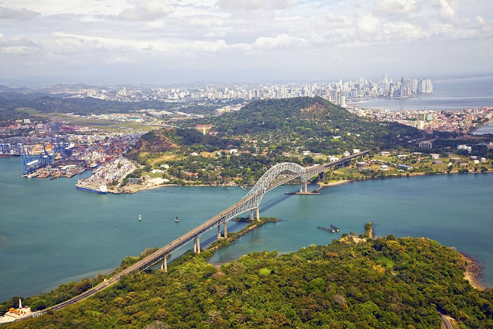 Aerial view of the Bridge of the Americas at the Pacific entrance to the Panama Canal with Panama City in the background.