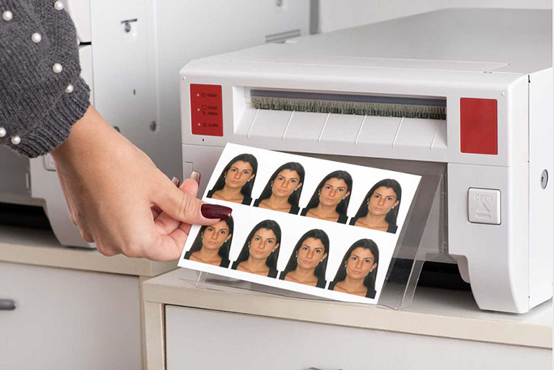 A women is holding her printed passport photos. 