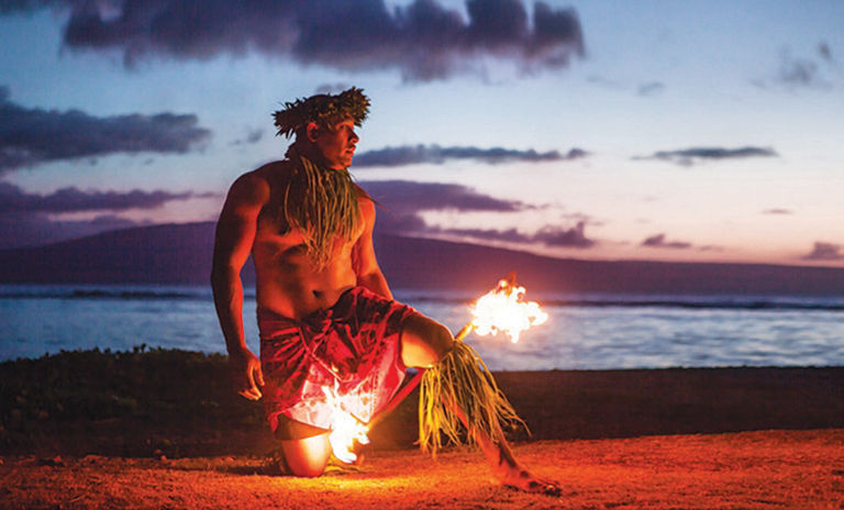 Male dancer, doing a fire show dance on the beach.