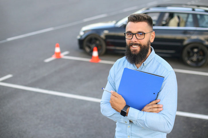 Mid adult male driving instructor. About 30 years old, Caucasian man.