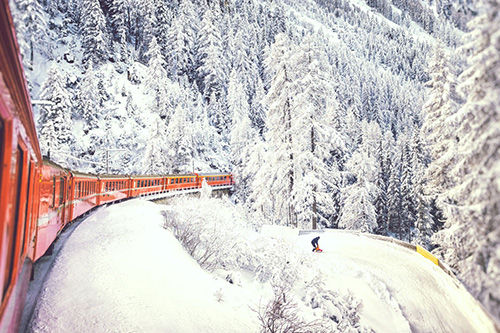 A train traveling along a mountain pass in the winter.