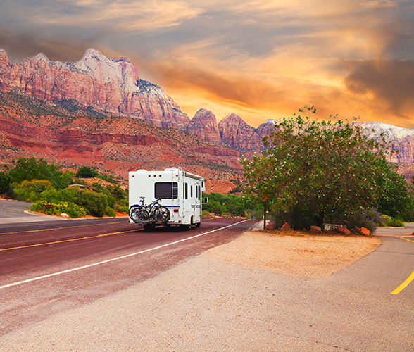 Trailer driving away with during a beautiful orange sunset with the red rocks in the background.