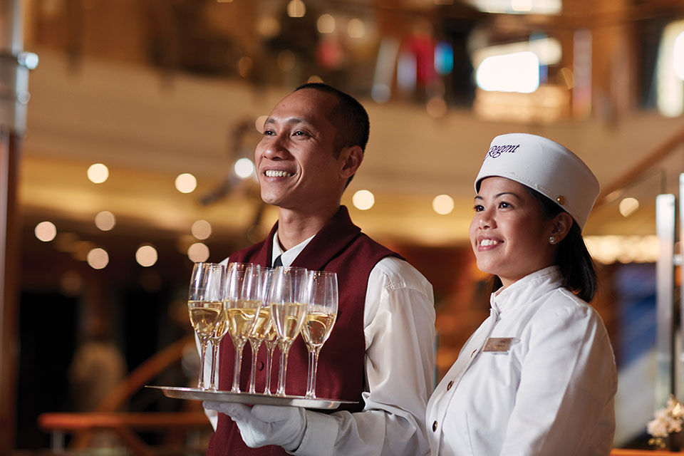 Regent service staff greeting guests with champagne...