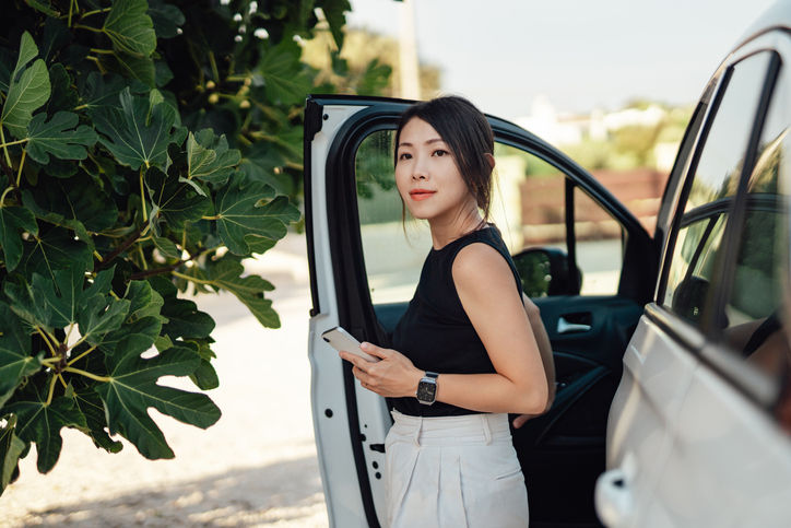 Businesswoman exiting her rental car.