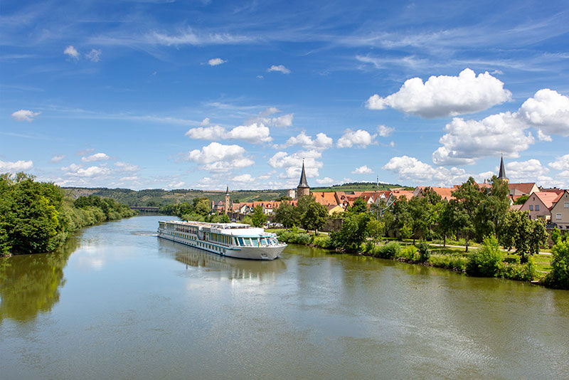 A river boat in Europe passing by a small town in Germany.