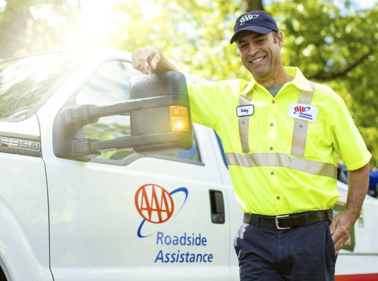 man standing next to aaa tow truck