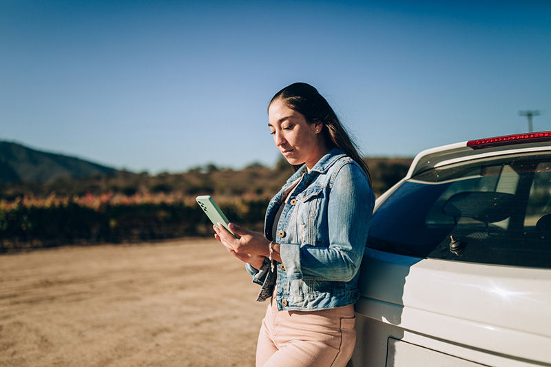 Young Chilean woman using cell phone outdoors