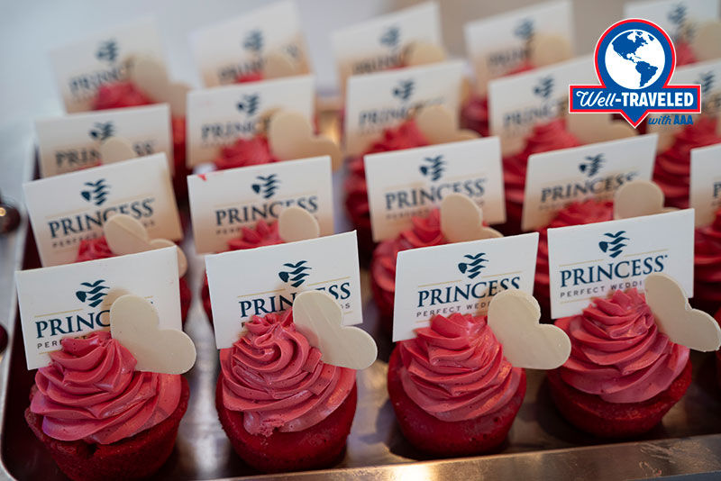 A row of pink cupcakes with Princess Cruises welcome cards