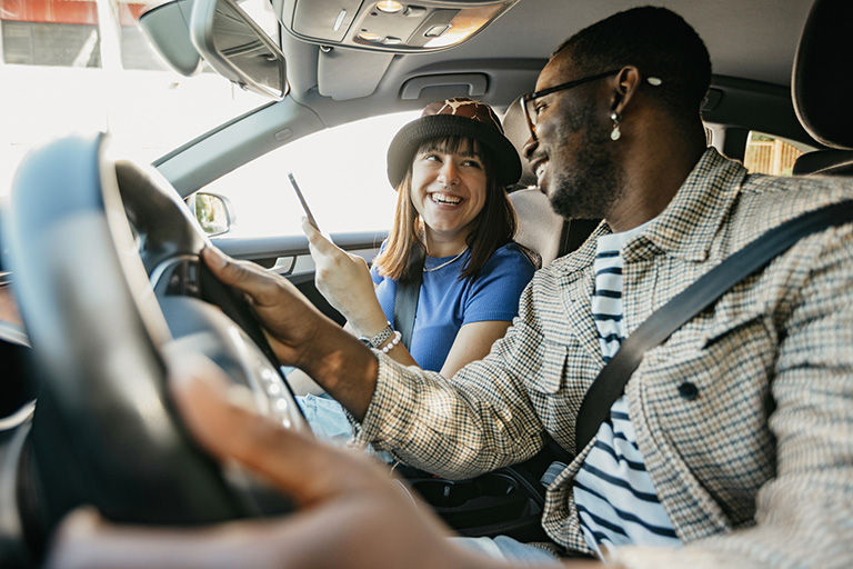 Couple in a car, smiling.