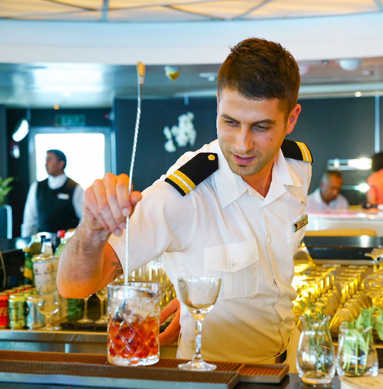 Seabourn crew member preparing a craft cocktail.
