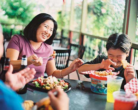 Family dining outside at busch gardens laughing togther.