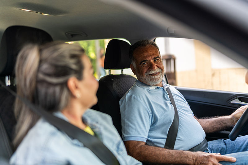 Senior couple talking inside a car