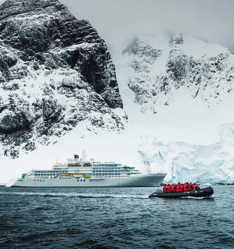 Silversea expedition ship with guests in a Zodiac in red cold-weather gear.