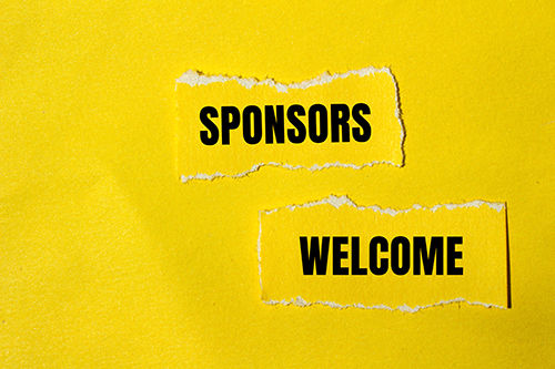 Bright yellow pieces of paper or torn one says sponsors the other says welcome. 