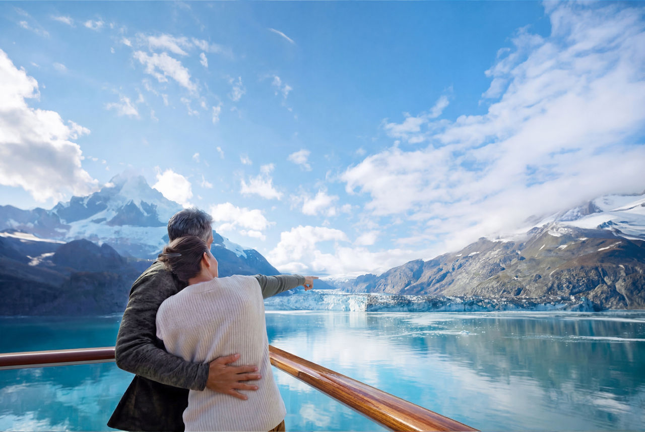 Couple looking at a glacier with Holland America Line 