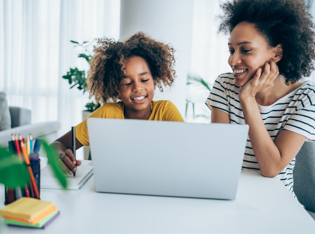 Mother and daughter on laptop together.