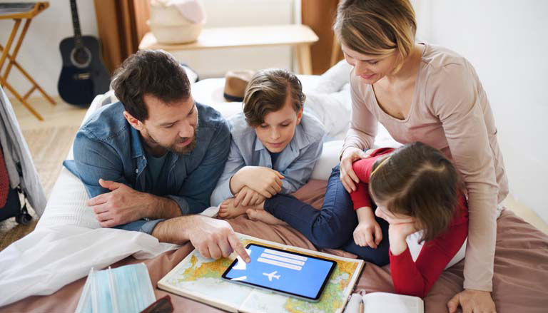 Arial view of a family planning travel with a tablet and map.