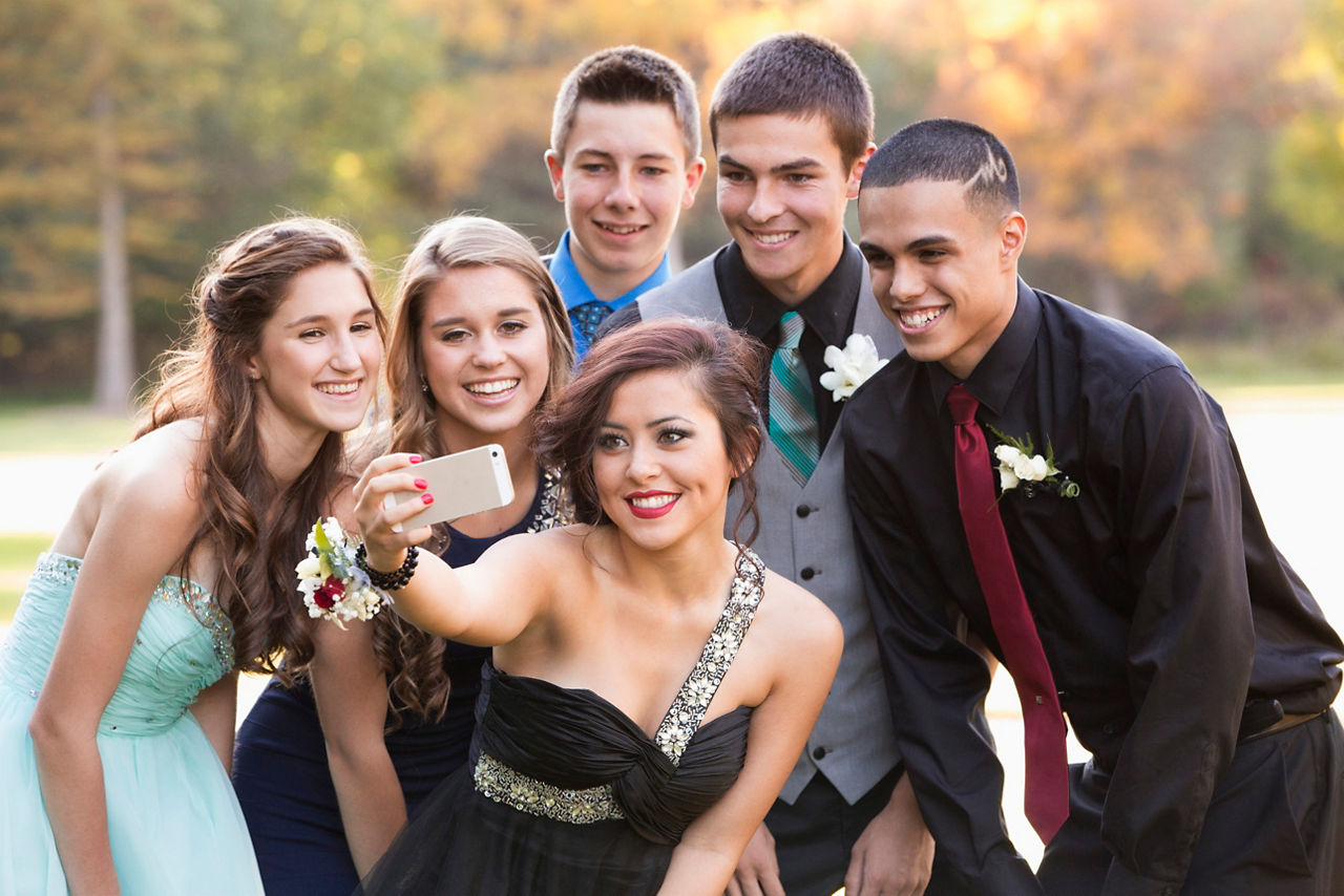 Teenagers taking selfie with cell phone before prom